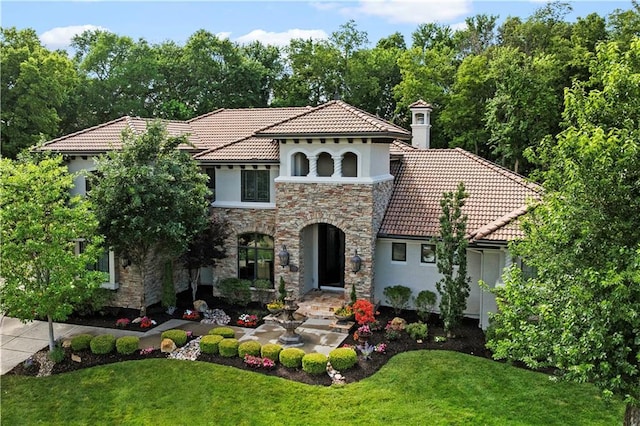 11110 W 146th Ter, Overland Park, KS 66221 - mediterranean / spanish-style house featuring stone siding, a tile roof, stucco siding, and a front yard