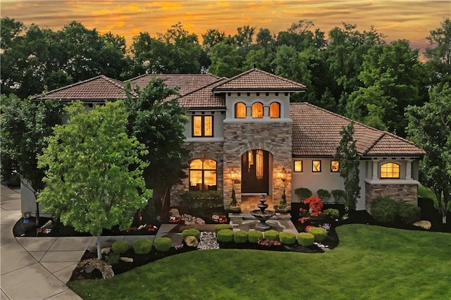 11110 W 146th Ter, Overland Park, KS 66221 - mediterranean / spanish-style home with stone siding, a tiled roof, a front yard, and stucco siding