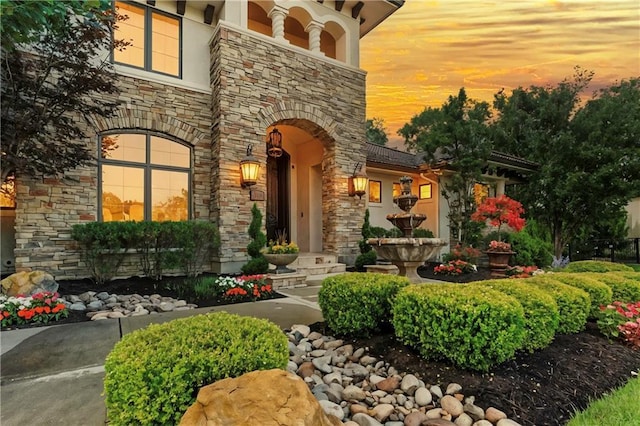 11110 W 146th Ter, Overland Park, KS 66221 - exterior entry at dusk with stone siding and stucco siding