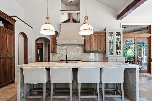 11110 W 146th Ter, Overland Park, KS 66221 - kitchen with custom range hood, backsplash, a center island with sink, freestanding refrigerator, and high vaulted ceiling
