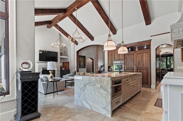 11110 W 146th Ter, Overland Park, KS 66221 - kitchen with arched walkways, built in features, high vaulted ceiling, stainless steel oven, and light stone counters
