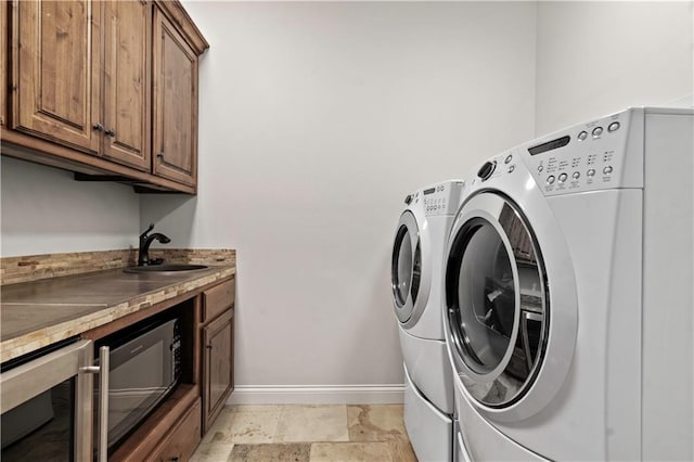 11110 W 146th Ter, Overland Park, KS 66221 - washroom with washer and clothes dryer, beverage cooler, and cabinet space