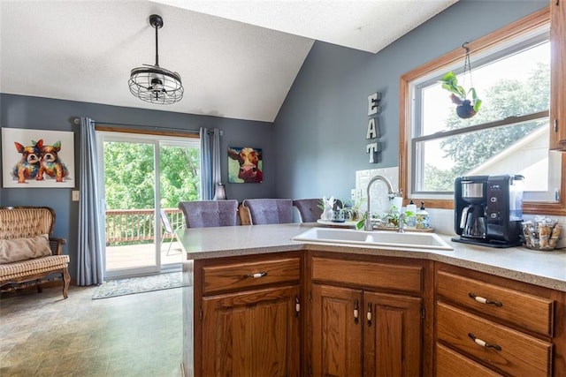 190 W Colleen Ct, Gardner, KS 66030 - kitchen featuring light countertops, brown cabinets, lofted ceiling, decorative light fixtures, and a peninsula