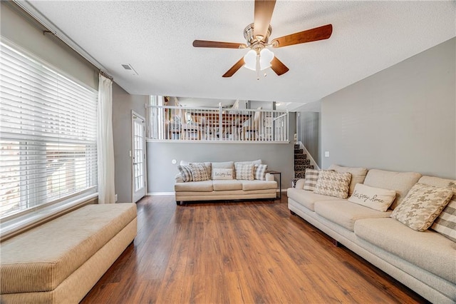 257 NE Chateau Dr, Blue Springs, MO 64014 - living room with wood finished floors, plenty of natural light, a textured ceiling, ceiling fan, and stairs