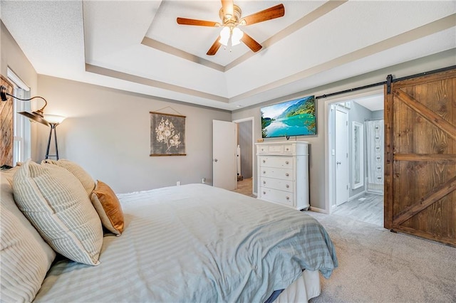 257 NE Chateau Dr, Blue Springs, MO 64014 - carpeted bedroom with a tray ceiling, a barn door, and ceiling fan