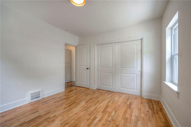 41 S 26th St, Kansas City, KS 66102 - unfurnished bedroom with light wood-style floors, a closet, and a textured ceiling