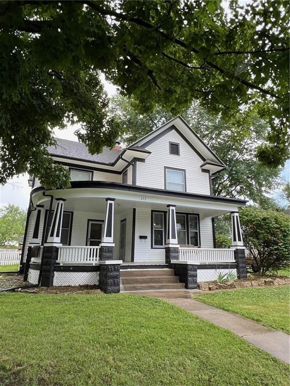 233 Main St, Osawatomie, KS 66064 - view of front of property featuring covered porch and a front yard