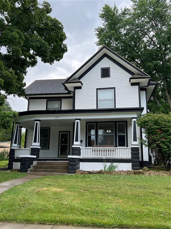 233 Main St, Osawatomie, KS 66064 - view of front of house with covered porch and a front yard