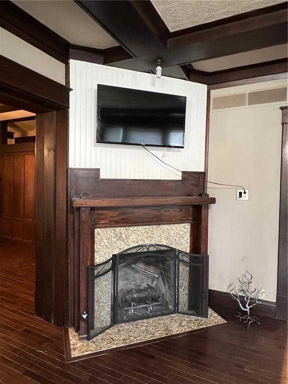 233 Main St, Osawatomie, KS 66064 - detailed view of wood finished floors, a tile fireplace, and beamed ceiling