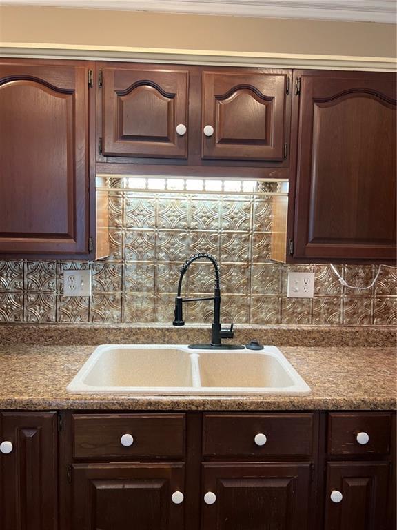 233 Main St, Osawatomie, KS 66064 - kitchen featuring dark brown cabinetry, decorative backsplash, and light countertops