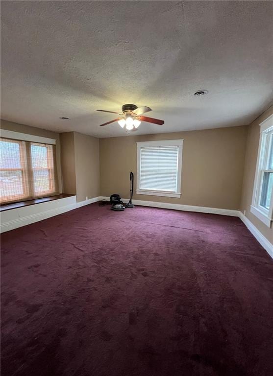 233 Main St, Osawatomie, KS 66064 - spare room with a textured ceiling, dark colored carpet, and ceiling fan