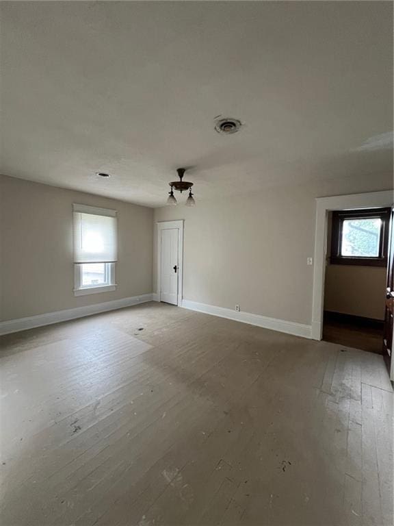 233 Main St, Osawatomie, KS 66064 - empty room featuring plenty of natural light and hardwood / wood-style flooring