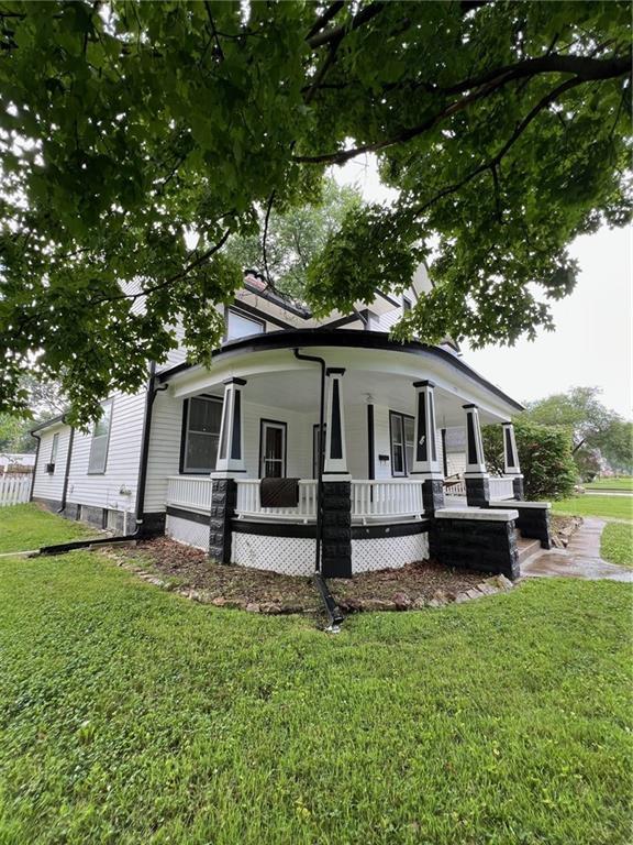 233 Main St, Osawatomie, KS 66064 - view of side of property featuring covered porch and a yard