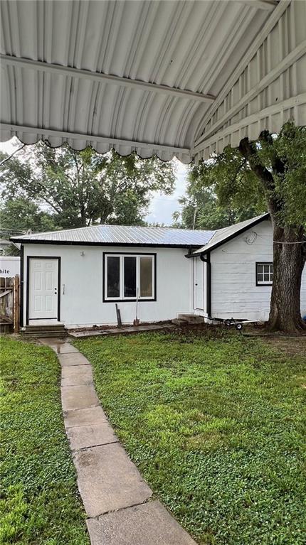233 Main St, Osawatomie, KS 66064 - single story home with a front lawn and a metal roof