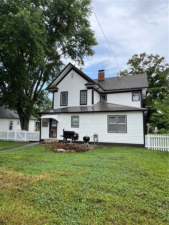 233 Main St, Osawatomie, KS 66064 - rear view of property featuring a chimney and a metal roof