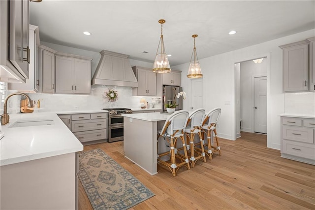 9010 N Denver Ave, Kansas City, MO 64156 - kitchen with premium range hood, appliances with stainless steel finishes, gray cabinets, a breakfast bar, and recessed lighting