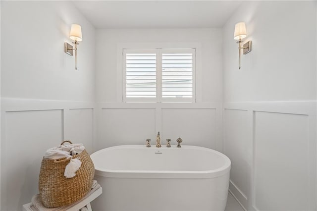 9010 N Denver Ave, Kansas City, MO 64156 - bathroom featuring a decorative wall, a freestanding bath, and wainscoting
