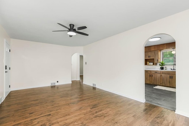 210 S 12th St, Leavenworth, KS 66048 - spare room with arched walkways, a ceiling fan, and wood finished floors