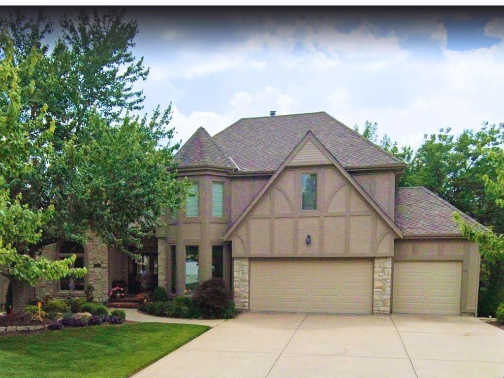 14116 England St, Overland Park, KS 66221 - english style home with stone siding, concrete driveway, a front yard, and stucco siding