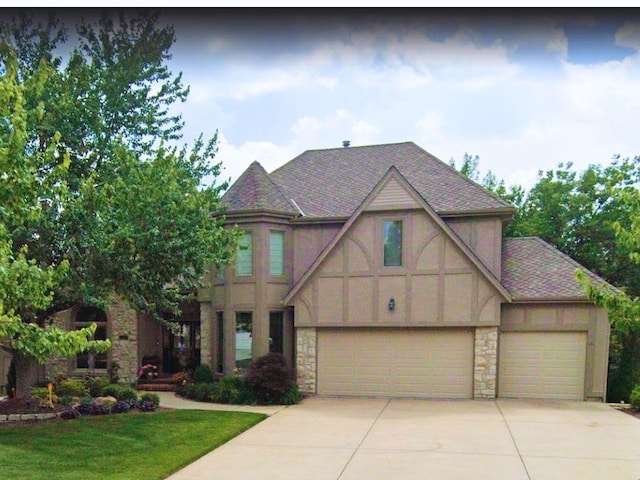 14116 England St, Overland Park, KS 66221 - english style home with stone siding, concrete driveway, a front yard, and stucco siding