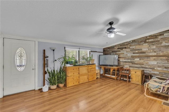 8036 Bellefontaine Ave, Kansas City, MO 64132 - entrance foyer with vaulted ceiling, wood walls, ceiling fan, light wood-style flooring, and ornamental molding