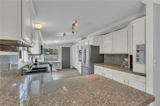 8036 Bellefontaine Ave, Kansas City, MO 64132 - kitchen with freestanding refrigerator, crown molding, white cabinetry, tasteful backsplash, and a textured ceiling