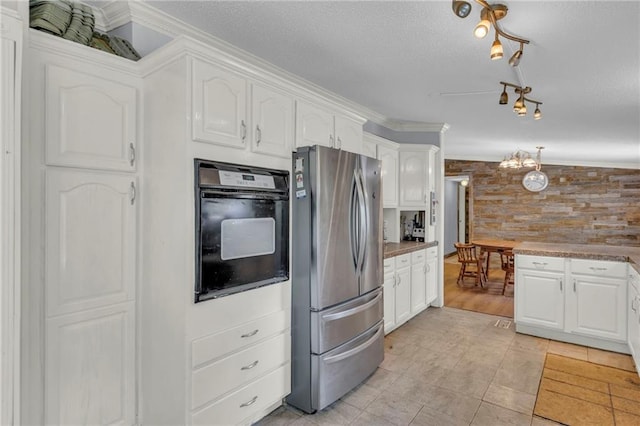 8036 Bellefontaine Ave, Kansas City, MO 64132 - kitchen with freestanding refrigerator, oven, white cabinets, rail lighting, and a textured ceiling