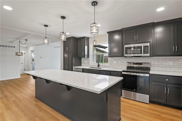 6600 W 93rd Ter, Overland Park, KS 66212 - kitchen featuring stainless steel appliances, a kitchen breakfast bar, a center island, light wood finished floors, and tasteful backsplash