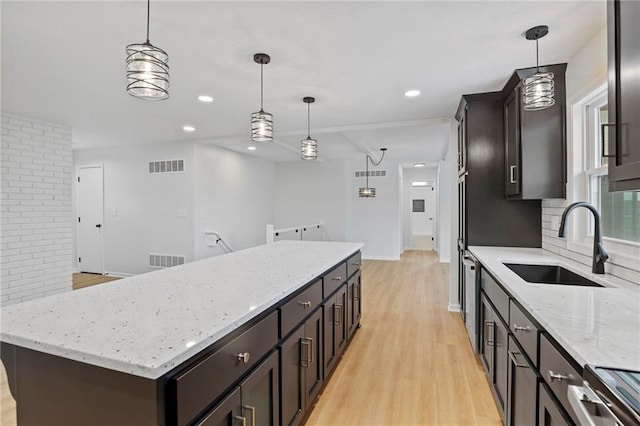 6600 W 93rd Ter, Overland Park, KS 66212 - kitchen featuring light wood-style floors, a kitchen island, decorative light fixtures, light stone counters, and recessed lighting