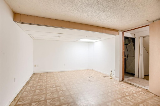 4400 N Brighton Ave, Kansas City, MO 64117 - finished basement with tile patterned floors and a textured ceiling