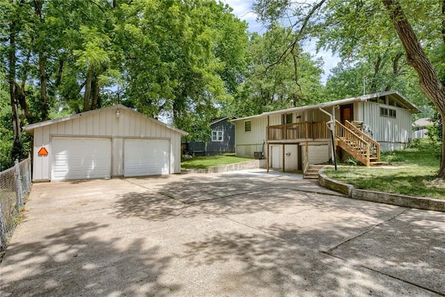 4400 N Brighton Ave, Kansas City, MO 64117 - view of front facade with stairs, an outbuilding, a detached garage, a deck, and board and batten siding