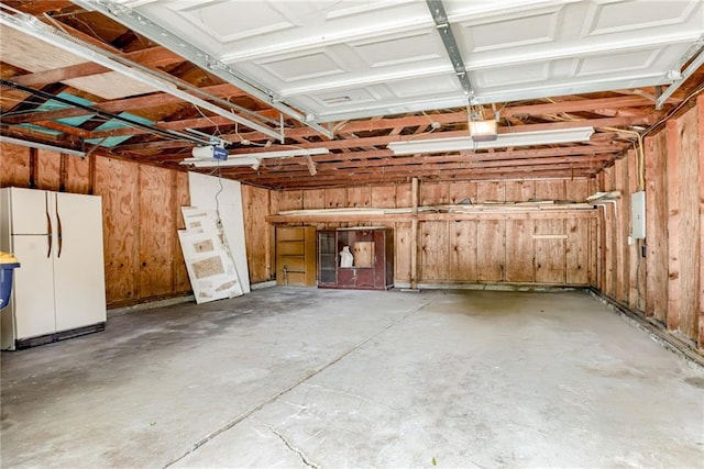 4400 N Brighton Ave, Kansas City, MO 64117 - garage featuring freestanding refrigerator and a garage door opener