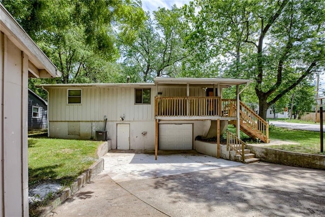 4400 N Brighton Ave, Kansas City, MO 64117 - back of house with concrete driveway, a garage, stairway, and a lawn
