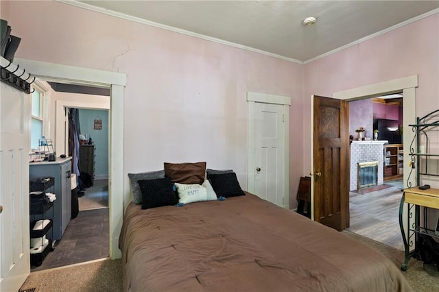 508 S Elm St, Ottawa, KS 66067 - carpeted bedroom featuring ornamental molding and a brick fireplace