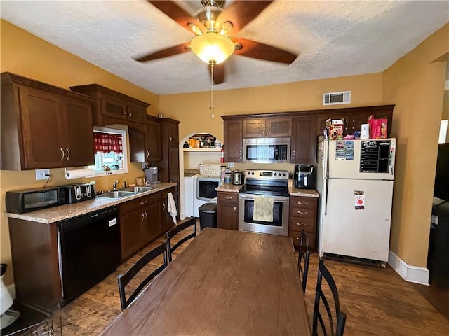 310 W 23rd St, Higginsville, MO 64037 - kitchen featuring black appliances, light countertops, dark wood finished floors, a ceiling fan, and washer and dryer