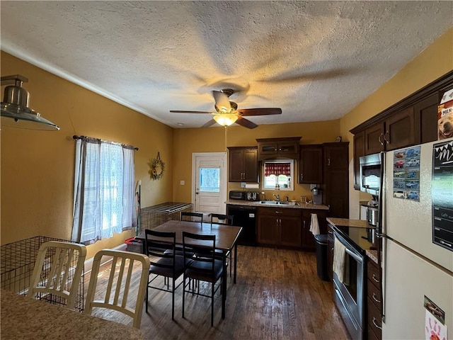 310 W 23rd St, Higginsville, MO 64037 - kitchen featuring appliances with stainless steel finishes, ceiling fan, dark brown cabinetry, dark wood-style flooring, and a textured ceiling