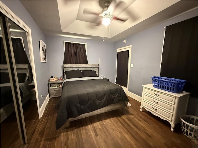 310 W 23rd St, Higginsville, MO 64037 - bedroom with a raised ceiling, wood finished floors, a closet, and a ceiling fan
