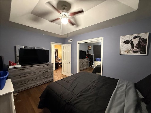 310 W 23rd St, Higginsville, MO 64037 - bedroom featuring a tray ceiling, wood finished floors, a closet, and ceiling fan