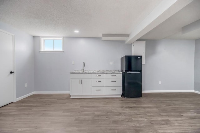 733 NE Colleen Dr, Lees Summit, MO 64086 - below grade area with freestanding refrigerator, a textured ceiling, light wood-style floors, and recessed lighting