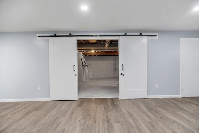 733 NE Colleen Dr, Lees Summit, MO 64086 - basement featuring a barn door and light wood-type flooring