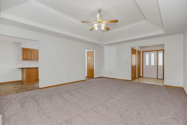 733 NE Colleen Dr, Lees Summit, MO 64086 - unfurnished living room with a raised ceiling, light colored carpet, and a ceiling fan