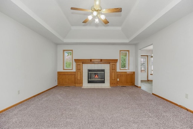 733 NE Colleen Dr, Lees Summit, MO 64086 - unfurnished living room with a tray ceiling, carpet floors, a ceiling fan, and a fireplace