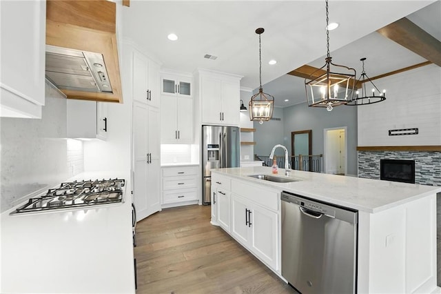13300 W 174th Pl, Overland Park, KS 66221 - kitchen featuring appliances with stainless steel finishes, light wood-style floors, a chandelier, a center island with sink, and decorative light fixtures