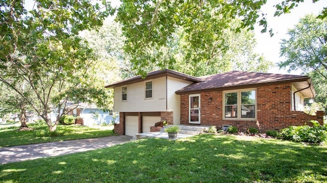 12205 W 67th Ter, Shawnee, KS 66216 - split level home featuring brick siding, an attached garage, a front yard, and driveway