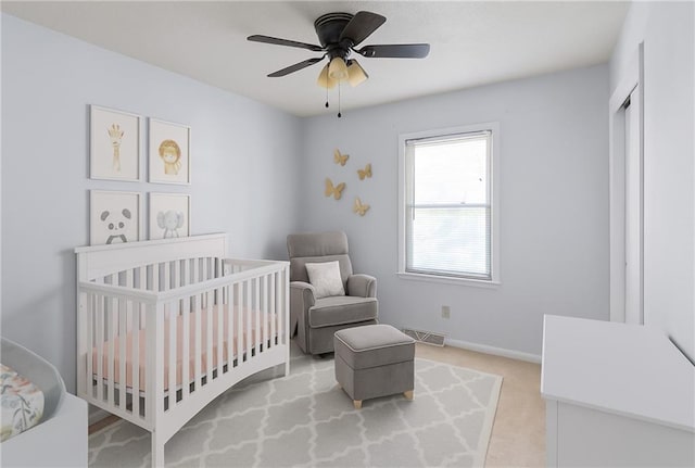 12205 W 67th Ter, Shawnee, KS 66216 - bedroom with light colored carpet, a crib, and a ceiling fan