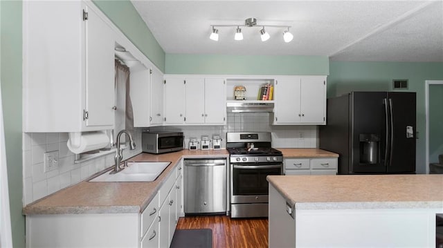12205 W 67th Ter, Shawnee, KS 66216 - kitchen with stainless steel appliances, under cabinet range hood, white cabinetry, light countertops, and tasteful backsplash