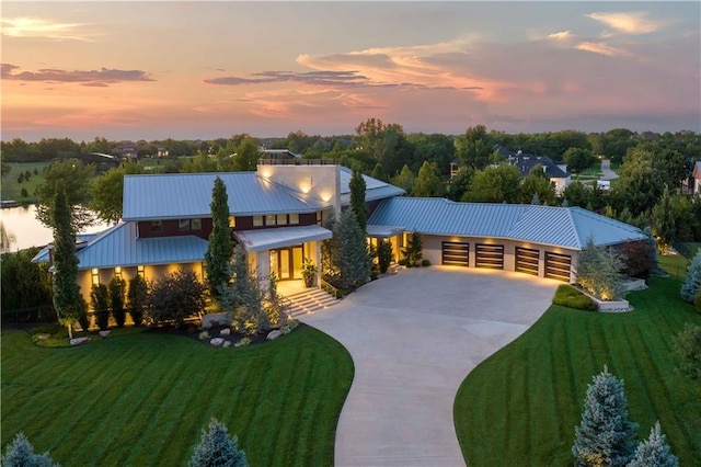 10712 W 165th St, Overland Park, KS 66221 - view of front of house with concrete driveway, a yard, a metal roof, and a garage