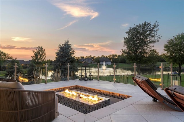 10712 W 165th St, Overland Park, KS 66221 - patio terrace at dusk featuring a fire pit, a patio area, and a water view