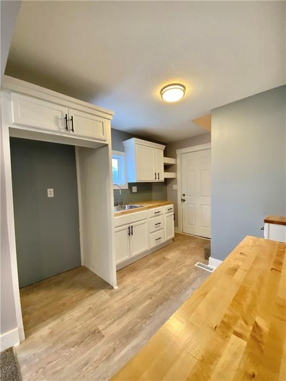 3046 N 27th St, Kansas City, KS 66104 - kitchen with butcher block counters, white cabinets, and light wood-type flooring