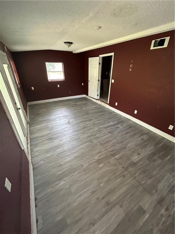 907 S Cedar Ave, Independence, MO 64052 - empty room with a textured ceiling and dark wood-style floors
